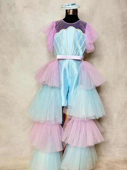The full mermaid look. The detachable, floor-length tiered trail in pastel pink and blue adds drama and magic, transforming the playsuit into a stunning gown.