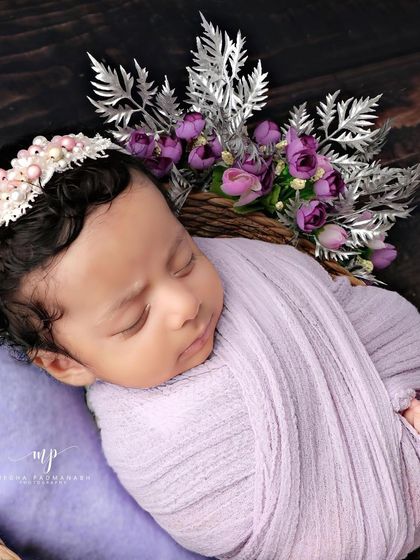 A close-up on the baby's face, showing off their beautiful hair and the pearl-adorned headband.