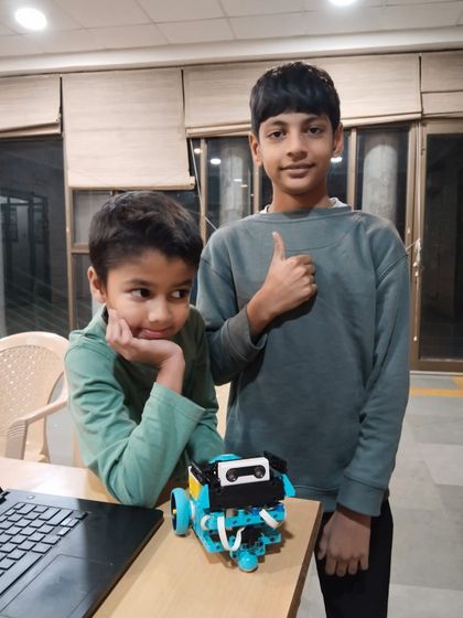 Success! After working together, these two students proudly pose with their completed robot. This sense of accomplishment is what builds confidence and a love for STEM.