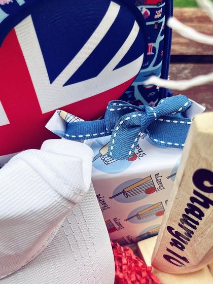 A detail from the cricket-themed hamper, showing a personalized cap and a mini cricket bat.