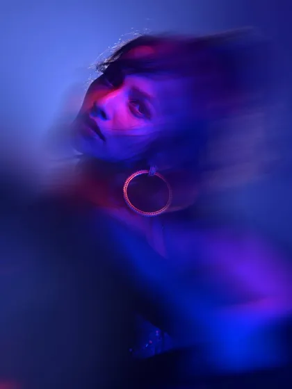 Another motion-blur portrait, this time capturing a sense of fluid movement. The swirling lights and the model's blurred form create a dreamlike and artistic image.