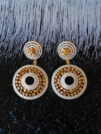 Can you freeze diamonds? Not really, but shooting on ice creates a fantastic texture. These diamond and yellow sapphire earrings for Jalak Jewels look extra brilliant against the frosty, dark background.