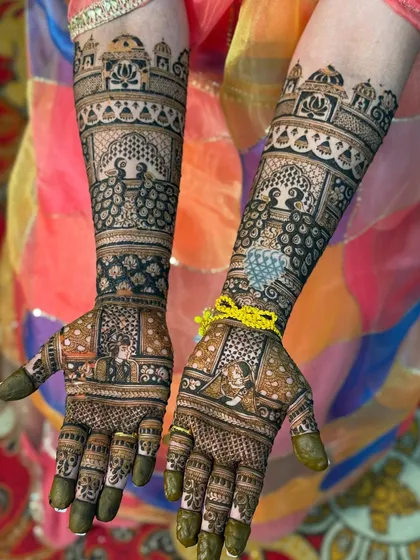A perfect example of symmetrical bridal mehendi, where both hands mirror each other beautifully. This design features classic bride and groom portraits, intricate peacocks, and traditional architectural motifs for a timeless look.