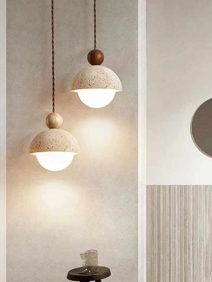 A pair of dome-shaped terrazzo pendants with wooden accents. This design combines several natural materials for a warm, earthy feel.