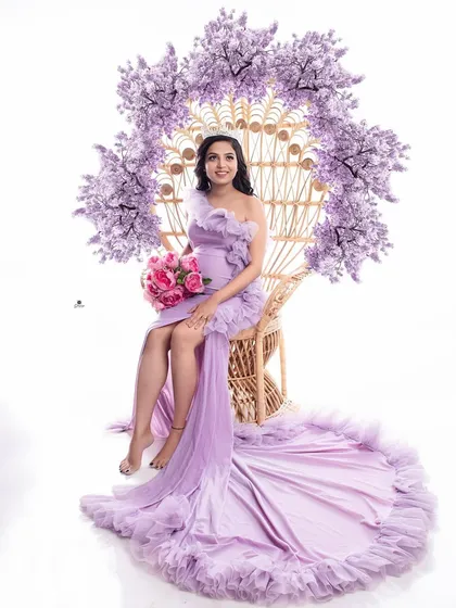 A beautiful and regal portrait with the client seated on the peacock chair, which is decorated with lavender flowers. The matching lavender gown creates a perfectly coordinated and stylish look.