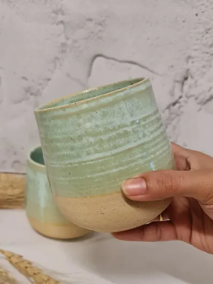 Holding one of my handcrafted tumblers. The throwing rings are visible, adding to the texture and handmade feel of the piece. These are made to last a lifetime.