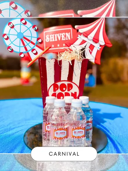 A themed centerpiece for a carnival party, featuring a popcorn box, a Ferris wheel cutout, and branded water bottles. These small details contribute to a cohesive and immersive event design.