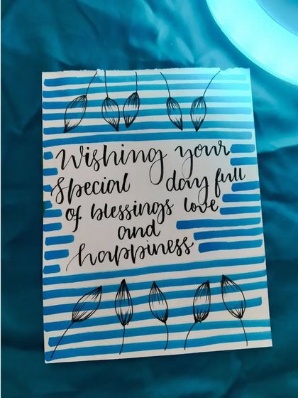 A simple and elegant birthday card with a blue striped background and a heartfelt, hand-lettered blessing.