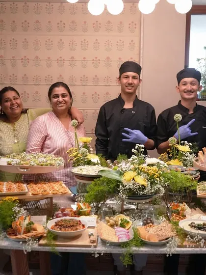 Meet the heart of our operations. This photo shows our dedicated team of chefs and founders, Khyati and Pooja, proudly standing behind a festive grazing table, ready to make your event a memorable one.