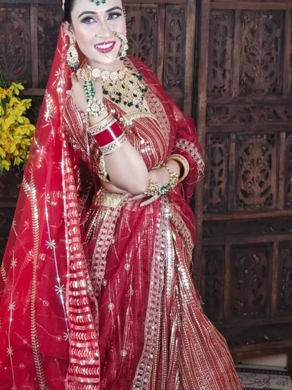 A full-length view of the red gota patti lehenga, showing its beautiful drape and the matching dupatta.