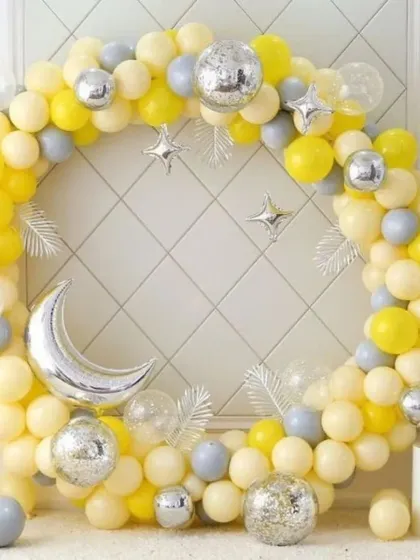 A celestial-themed balloon hoop perfect for birthdays or baby showers. The arrangement features yellow and grey balloons with silver moon and star foil accents and disco balls for extra shine.