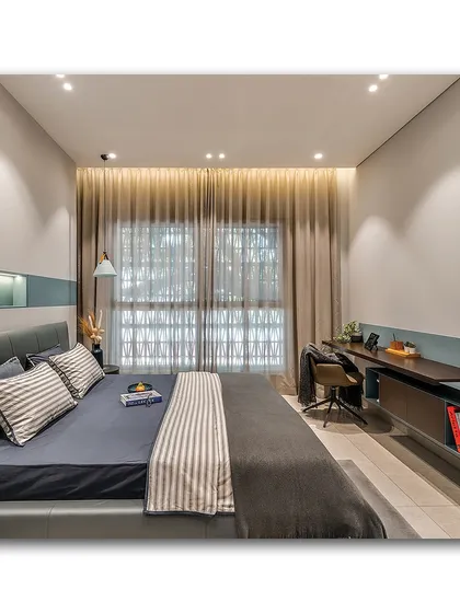 A modern and functional bedroom with a long, built-in wooden desk that doubles as a workspace. The cool blue tones and clean lines create a calm and productive environment, complemented by soft, ambient lighting.