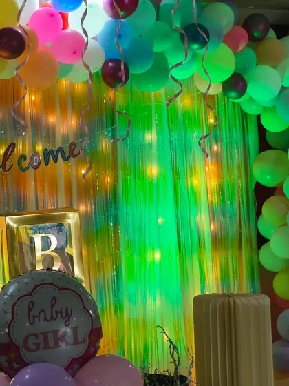 A closer look at the whimsical 'Welcome Baby' setup, with a 'Baby Girl' foil balloon and a mix of colorful lights and balloons.