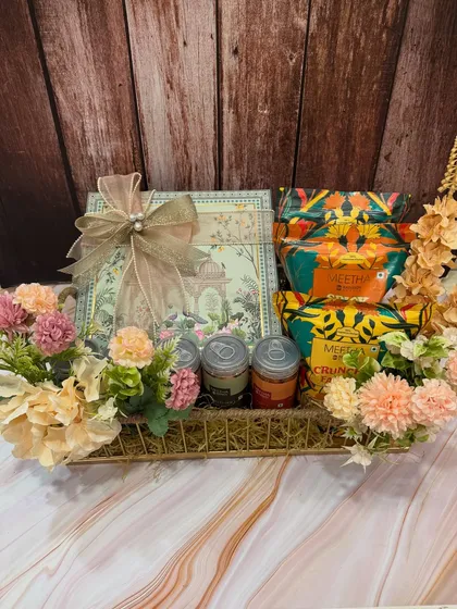 A close-up of the beautifully packaged snacks and the elegant gift box included in our 'Chatpati & Meethi' Rakhi hamper.