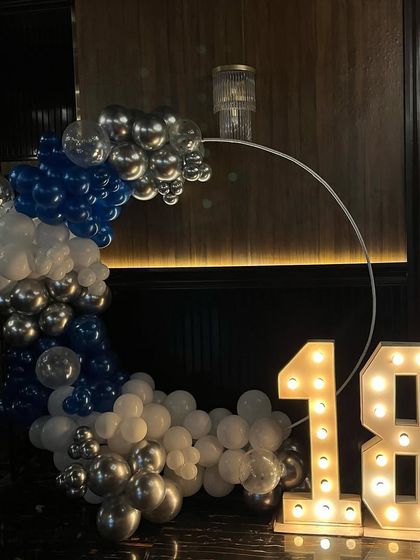 Another angle of the 18th birthday party setup with a blue, white, and silver balloon arch.