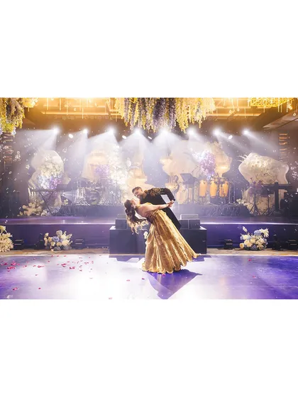 A classic dip at the end of a romantic dance. The dramatic lighting and stage setup make this a picture-perfect moment from the Sangeet night.