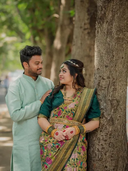 The couple shares a loving look while posing by a tree. This photo from their cross-cultural engagement shoot highlights their connection and the blend of their traditions.