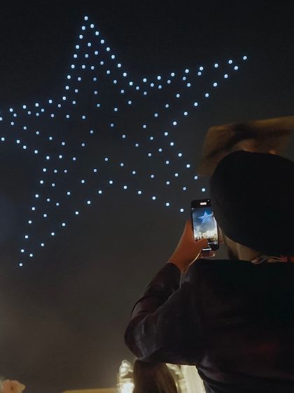 A guest captures a star formation on their phone. Our shows are designed to be not just watched, but experienced and shared, creating countless picture-perfect moments.