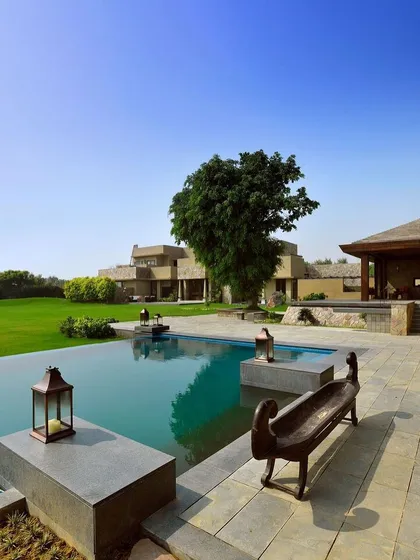 At C Farm in Delhi, the garden, pavilion, and infinity pool are designed with a purity of line and form. This space exemplifies how landscape architecture can extend the home's living area, creating a tranquil retreat for relaxation and connection with the outdoors.