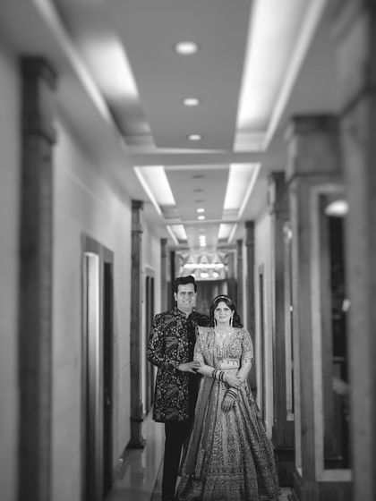 A powerful black and white portrait in a hotel corridor. The leading lines of the hallway draw all the attention to the couple, creating a striking and cinematic composition.