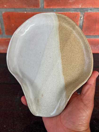 A beautiful, shell-shaped spoon rest or trinket dish made by a student. The two-tone glaze effect is simple yet so effective.