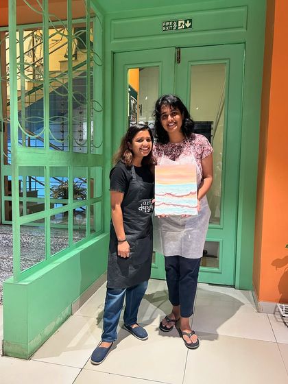 Two friends posing with their finished artwork. The smiles on their faces show the sense of accomplishment and fun that our workshops bring.