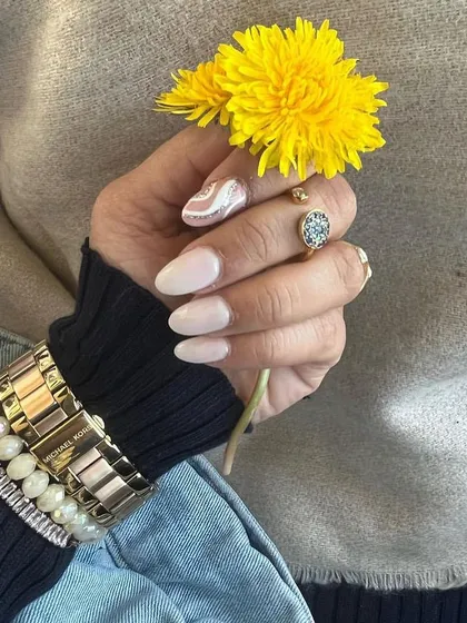 Another beautiful shot from a happy client. Her elegant, light-colored manicure with a single swirl accent nail looks stunning paired with her accessories.