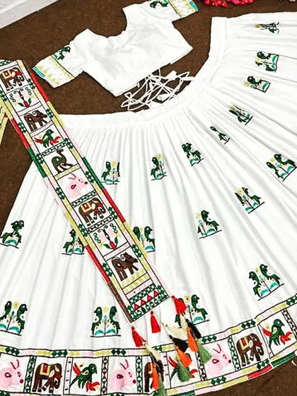 The complete white chaniya choli set laid out, showing the intricate embroidery on the skirt, the matching blouse, and the detailed dupatta. The tie-up back on the blouse ensures a comfortable fit.