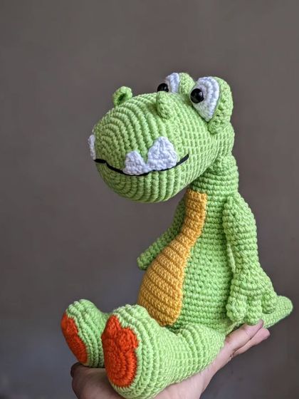 Another angle of the dinosaur held in my hand, showing his cheerful design.