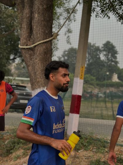 A player takes a moment during a water break, focused and ready for the next part of the training session.