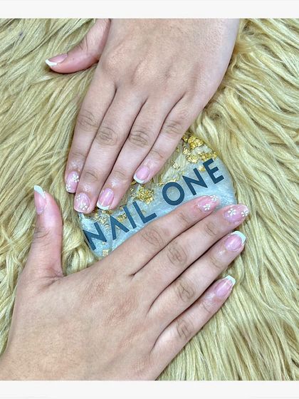 A simple and delicate manicure featuring a sheer, natural base with a light dusting of glitter at the tips. This is the perfect choice for a subtle, "your nails but better" look.