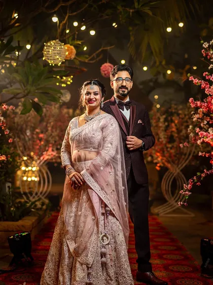 A classic, elegant portrait of a beautiful Marathi couple at their reception, set against a stunning floral backdrop.