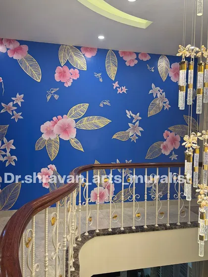 A stunning double-height staircase wall featuring gold foil and pink florals against a vibrant blue background. The scale of the work makes a huge impact in this grand home.