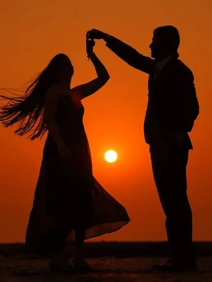 A classic sunset silhouette shot. We play with light and shadow to create these timeless, romantic images that focus purely on the couple's connection.