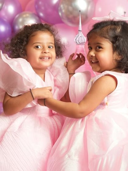 A sweet moment of connection between two sisters during their princess-themed photoshoot. These are the unscripted interactions that I love to capture, showing their genuine bond.