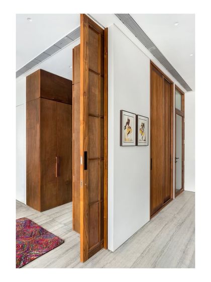 This image from the Limestone Residence shows how we use pivoting doors to create dynamic and flexible spaces, connecting a walk-in closet area to the main bedroom.