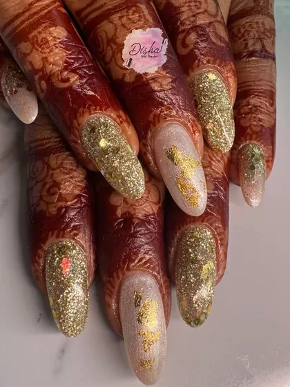 A stunning Karwachauth look. These glittery gold nails with foil accents look absolutely beautiful against the intricate henna design.