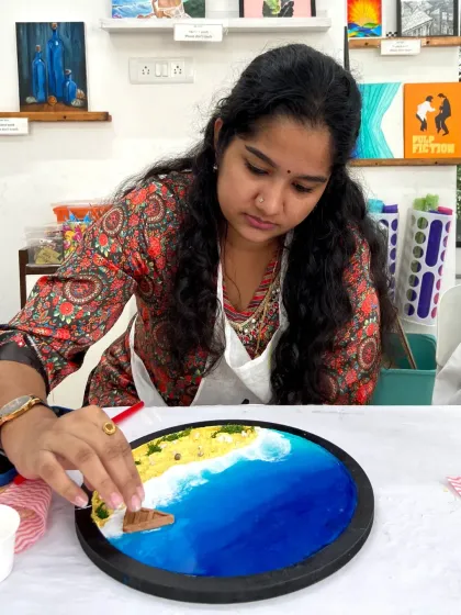 A participant carefully adds details to her resin beach art, creating a unique and personal piece.