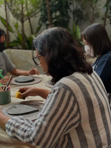 A participant at our cafe workshop focused on smoothing the edges of her wall plate. I love hosting these pop-up sessions that bring art into everyday spaces.