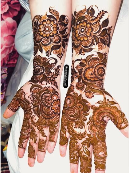 Two different but complementary designs on each hand. One features a bold floral pattern while the other has a more delicate, leafy style.