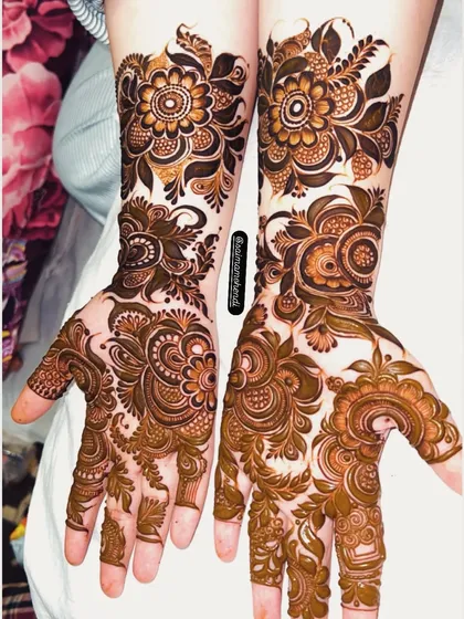 Two different but complementary designs on each hand. One features a bold floral pattern while the other has a more delicate, leafy style.
