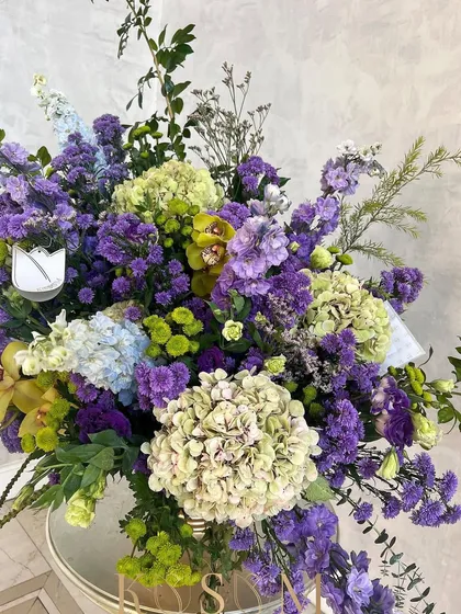 The full view of this sprawling arrangement of limes and violets. It's a lush and opulent design, perfect for making a statement at any event or celebration.