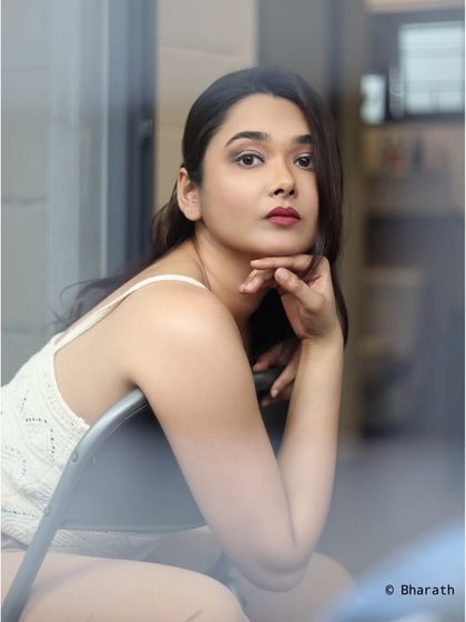 A classic, thoughtful pose by a window, shot from outside to create a sense of looking in.