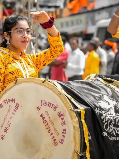 The color version of the dhol player with glasses, focused and ready.