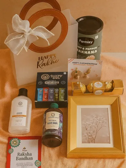 A lovely Rakhi hamper for your favorite couple. It includes a photo frame, shower gels for him and her, makhana, coffee, Ferrero Rocher, and a matching lumba and rakhi set.