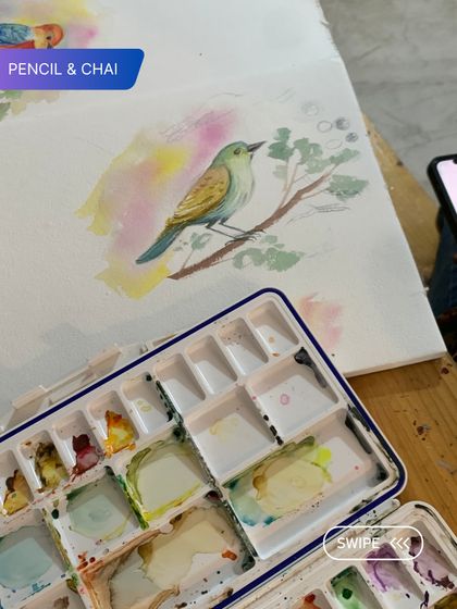 A work-in-progress shot of a delicate bird painting in watercolor. Notice the soft, blended background and the clean lines of the subject, showcasing key techniques we teach.