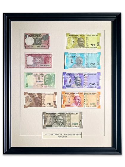 The complete framed collection of currency notes, featuring a custom-engraved caption for a birthday gift. This is a perfect example of how we can personalize frames for any special occasion.