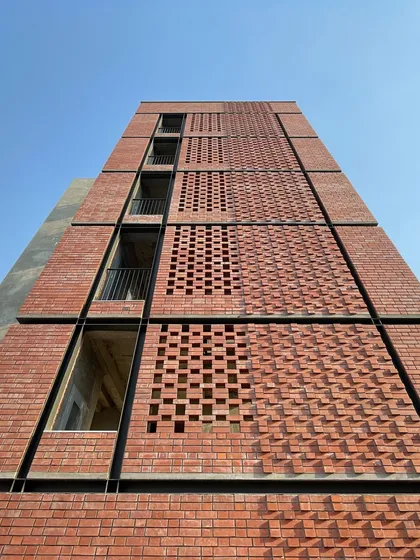 We believe in the honesty and beauty of materials. The facade of the JIM Boys Hostel in Noida features an intricate pattern of exposed brickwork, creating a visually dynamic surface that responds to light and shadow while connecting the new building to the existing campus aesthetic.