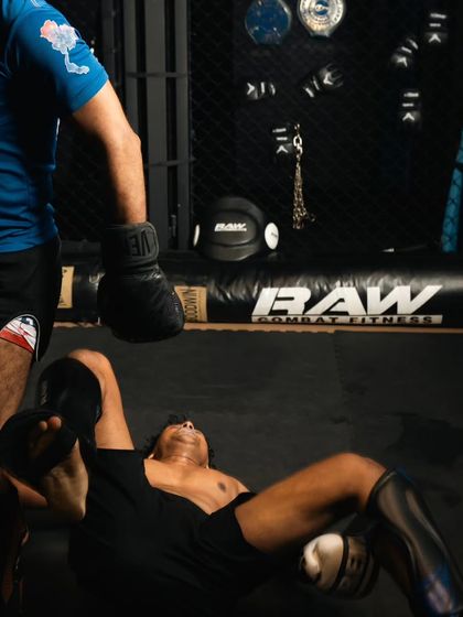 A fighter on the ground after a tough sparring exchange, showing the reality of the grind.