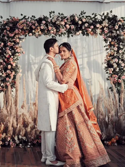 Framed by a beautiful floral arch, this is a portrait of pure happiness. We guide our couples into poses that feel natural and comfortable, allowing their genuine love to shine through against a beautifully styled backdrop.